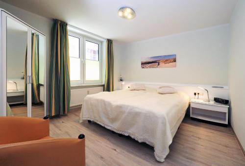 霍恩维舍多夫Fietje 206 - Hohen Wieschendorf的卧室配有白色的床和椅子