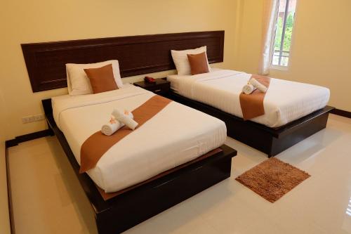 班武里府班波普拉度假村的一间卧室设有两张床,里面饲养着动物。