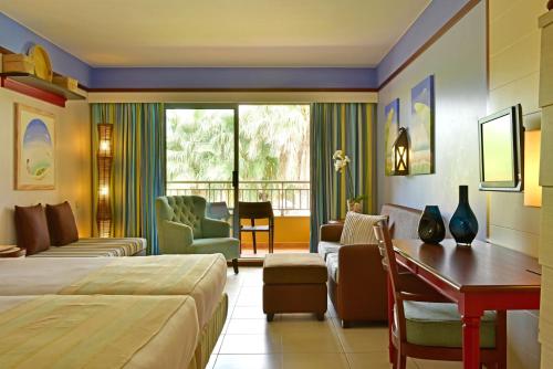 圣港Pestana Porto Santo Beach Resort & SPA的配有一张床和一张书桌的酒店客房