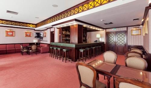 法蒂玛卢克希沐恩迪酒店的餐厅设有酒吧和桌椅