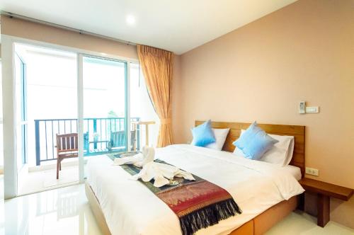 南芭堤雅格居公寓式酒店的一间卧室设有一张大床和一个大窗户