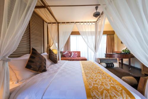 Kampong Ayer TawarTok Aman Bali Beach Resort @ Beachfront的一间卧室配有一张带窗帘的大床