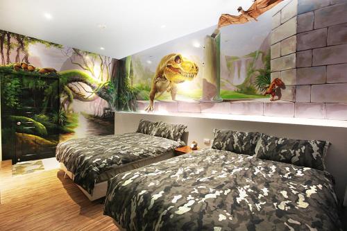 花莲市太阳花3D浮雕民宿的一间卧室设有两张床和恐龙壁画