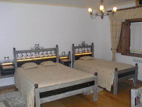 曼泰加什Descanso Serrano的一间卧室配有两张床和吊灯。