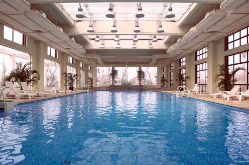 南京Jinling Resort Nanjing的一座大型游泳池,位于一座带窗户的建筑内