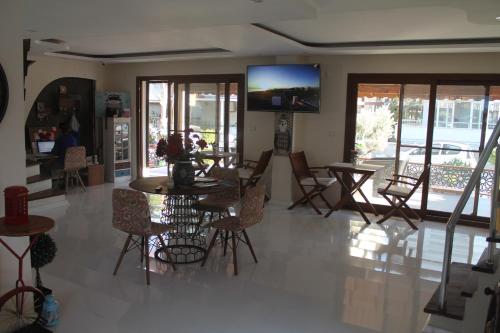 迪基利Lila Butik Hotel Dikili的客厅配有桌椅和电视。
