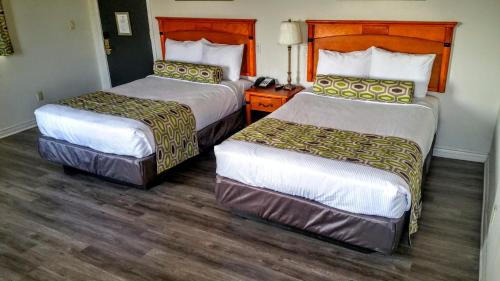 格伦代尔Jewel City Inn的配有2张床的酒店客房,铺有木地板