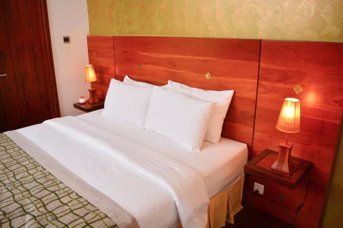 科伦坡独特大厦豪华精品套房酒店的卧室配有一张带白色床单和枕头的大床。