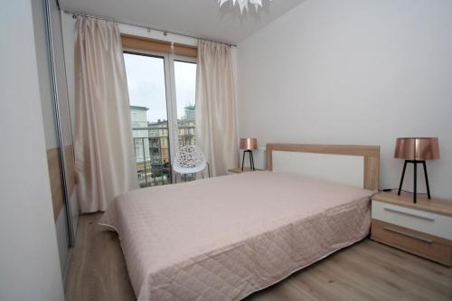 科沙林100-SIO Apartamenty的一间卧室设有一张床和一个大窗户