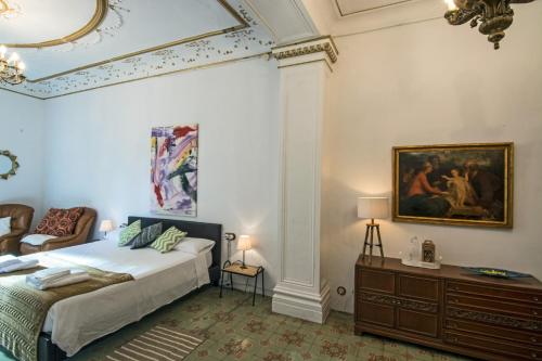 巴拉格尔Cal Comabella的卧室配有一张床,墙上挂有绘画作品