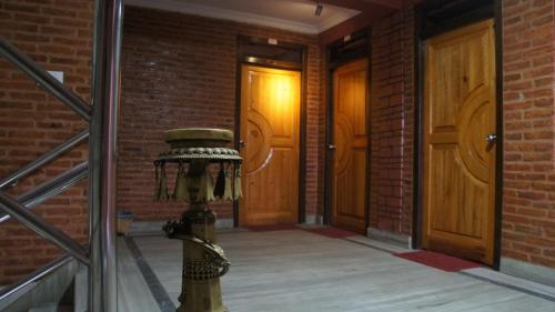 巴克塔普尔City Guest House的砖砌走廊上的消防栓,有两扇门