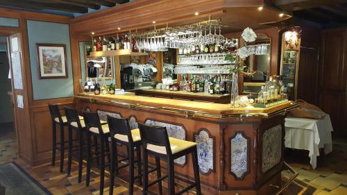 Germigny-lʼEvêqueLOGIS - Hôtel & Restaurant Le Gonfalon的酒吧周围摆放着一束椅子