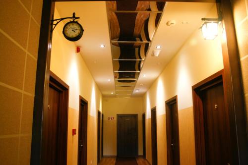 什切青Hotel 7的天花板上带时钟的走廊和带门的走廊