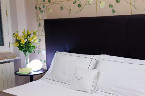 克罗托内美露住宿加早餐旅馆的一张带黑色床头板和花瓶的床
