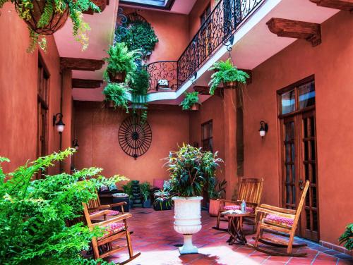 巴拿马城La Isabela Suites的建筑中带椅子和植物的庭院
