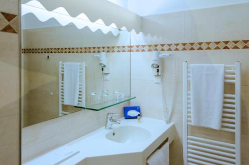 汉堡赫尔格兰岛酒店的白色的浴室设有水槽和镜子