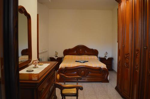 维贾内洛Casa Vacanze Cuore del Pollino的一间卧室配有一张床、梳妆台和镜子
