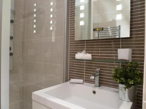 波尔多LES TROIS CHANDELIERS un petit paradis en plein centre ville的浴室设有白色水槽和镜子