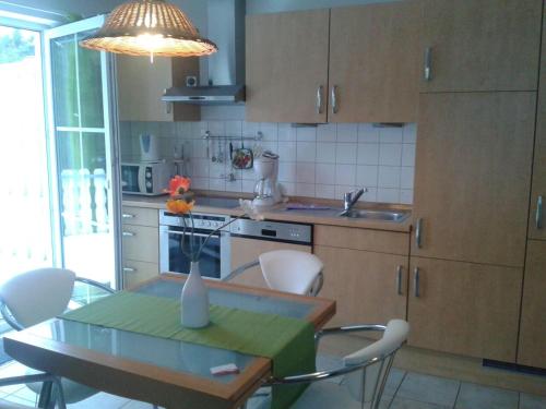 普雷罗Ferienwohnung Buchenpark的厨房配有桌椅、桌子和大灯