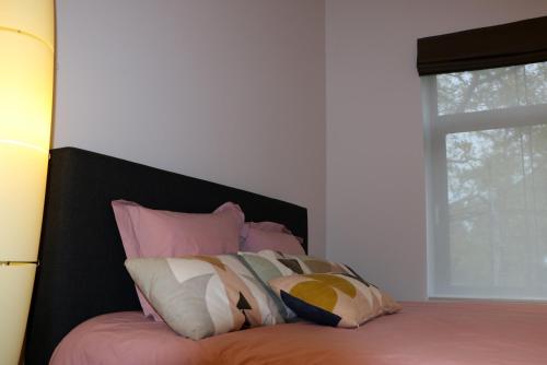 斯帕Un Air de Château的一张带粉色和白色枕头的床和窗户