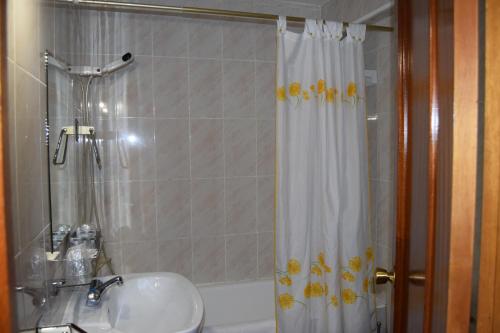拉斯卡弗里亚Hotel Rural Marcos的浴室配有水槽和带浴帘的淋浴