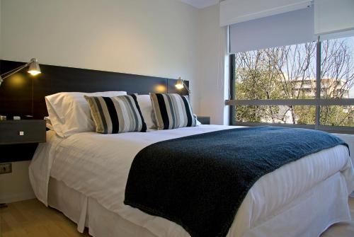 圣地亚哥海德堡豪斯公寓酒店的一间卧室设有一张大床和大窗户
