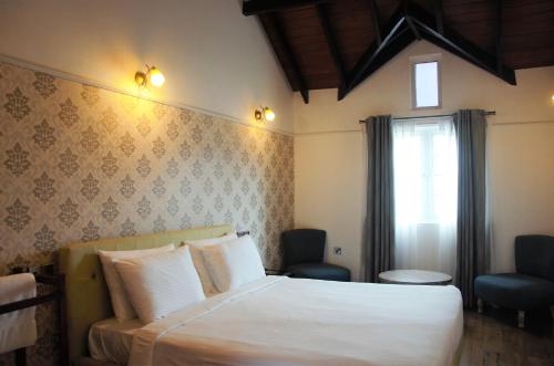 努沃勒埃利耶湖畔小屋乡村民宿的卧室配有白色的床和窗户。