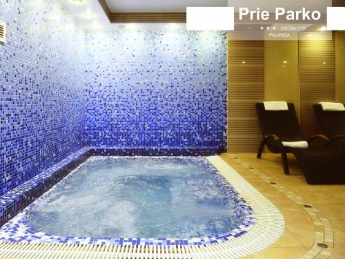 帕兰加Palanga Park Hotel的蓝色瓷砖的房间内的热水浴缸