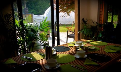 科尔福德The Lodge Rooms的一张带绿色餐巾和盘子的木桌