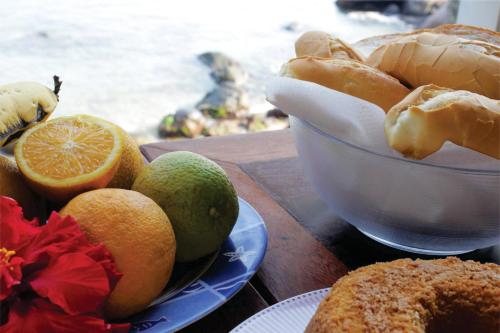 阿拉夏奇巴海滩Pousada Cibeles的一张桌子,上面放着一碗水果和一盘面包
