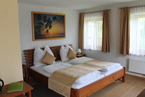 阿特湖畔努斯多夫诺伯雷时纳农家乐的卧室配有带白色枕头的大床
