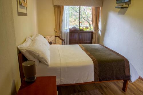 昆卡洛雷特住宿加早餐旅馆的一间卧室配有一张带窗户和桌子的床