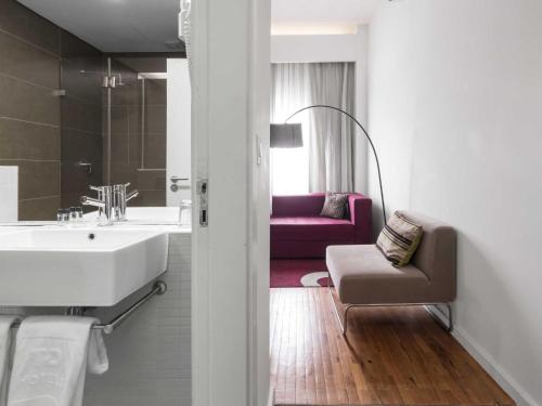 马普托马普托蒂沃里酒店的一间带水槽的浴室和一张沙发