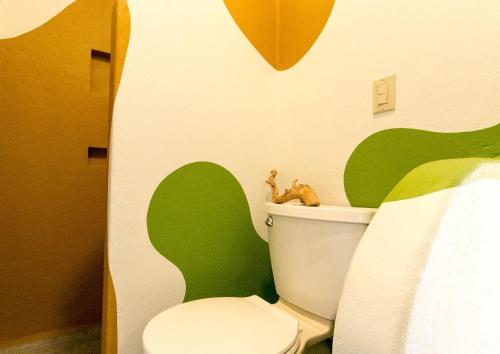 波波约Red Pepper Popoyo的浴室配有带绿色和白色墙壁的卫生间。
