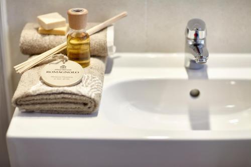 Noventa VicentinaHotel da Romagnolo的浴室水槽配有1瓶肥皂和毛巾