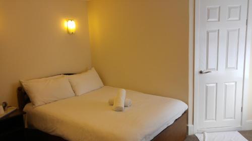 伦敦斯特拉特福德市景旅馆的坐在房间里床上的泰迪熊