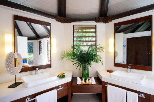 Mbukama雅莎娃度假酒店&Spa的浴室设有2个水槽和2面镜子