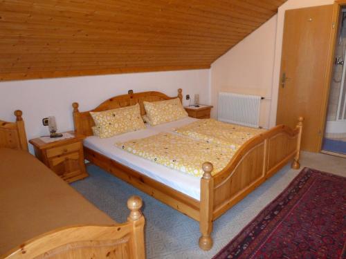 洛豪Gästehaus Zussner的一间卧室配有木床和2个床头柜