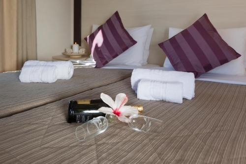 加利萨斯弗朗索瓦丝酒店的床上一瓶葡萄酒和一朵鲜花