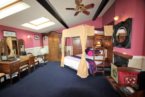 彼索普斯托福皮特休憩酒店的卧室设有粉红色的墙壁和一张带书桌的床