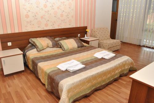 奥格尼亚诺沃Family hotel Gradina的一间卧室配有一张大床和毛巾