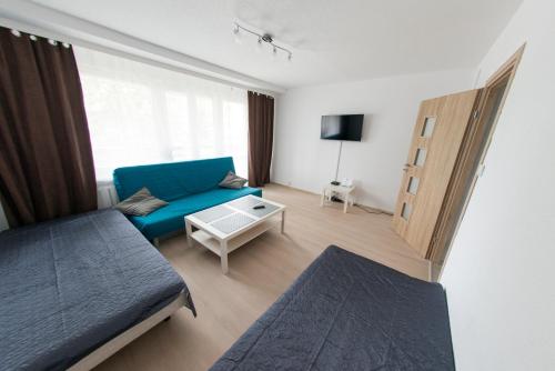 斯塔洛瓦沃拉Apartament pracowniczy的客厅配有蓝色的沙发和桌子
