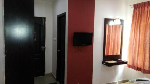 马杜赖Sri ArulMuthu Residency的一间设有门的房间和墙上的电视
