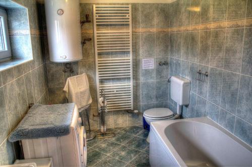 RatkovicaApartman Anka的带浴缸、卫生间和盥洗盆的浴室