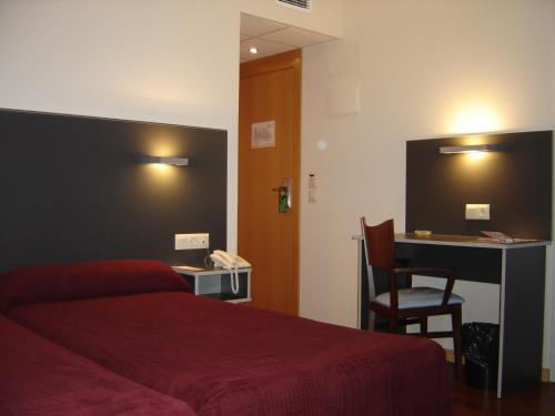 普埃布拉-德阿里冯德阿尔菲登酒店的酒店客房配有红色的床和书桌