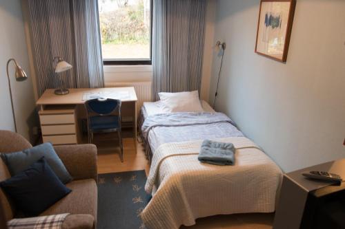 米凯利Gasthaus Mikkeli的酒店客房 - 带两张床、一张桌子和一把椅子