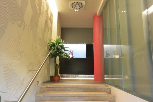 米兰科拉罗酒店的走廊上设有红色柱子和盆栽植物