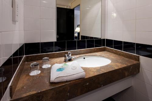 伯明翰伯明翰新街车站布里塔尼亚酒店的浴室设有水槽、毛巾和镜子