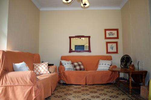 埃尔乔罗Cortijo Don Rodrigo的客厅配有橙色沙发和镜子