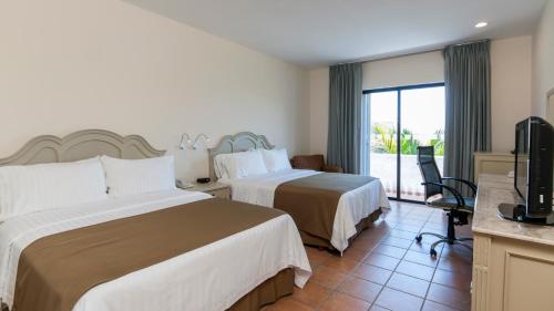 卡门城卡门城假日酒店的酒店客房设有两张床和电视。